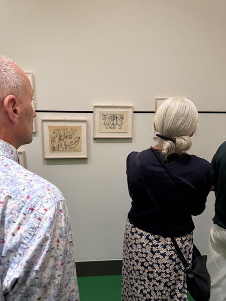 This photo captures visitors admiring framed artworks inside a museum located on Museumstraat, Zuid, Amsterdam